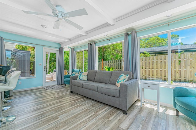 sunroom / solarium featuring wood finished floors, beamed ceiling, baseboards, and a deck