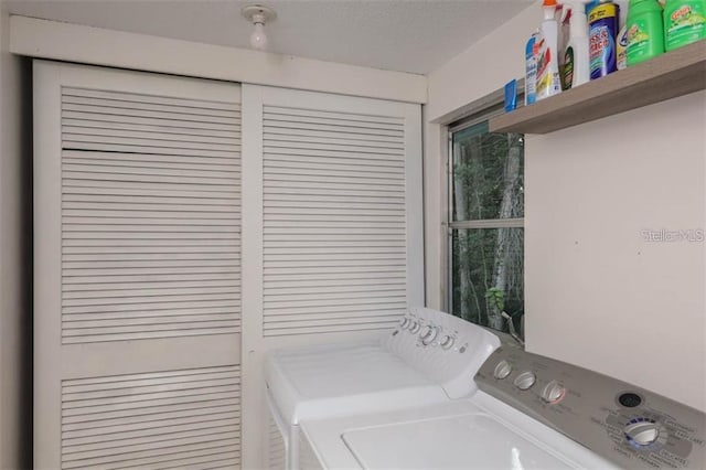 washroom featuring laundry area, washing machine and dryer, and a textured ceiling