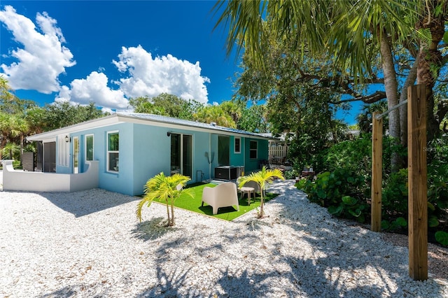 rear view of property featuring a sunroom and stucco siding