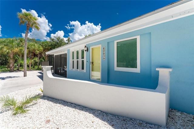view of property exterior featuring a sunroom and stucco siding