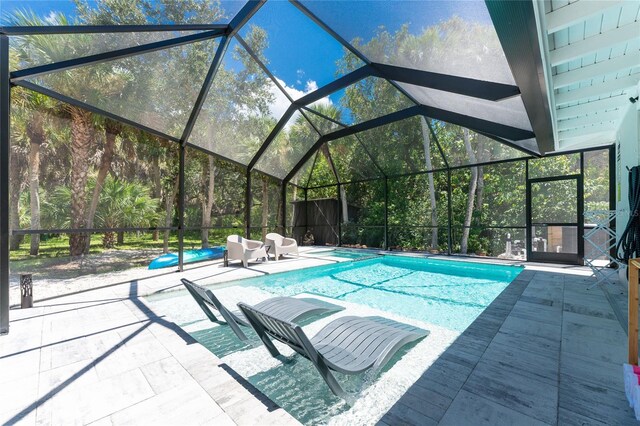 view of swimming pool featuring a patio area, a pool with connected hot tub, and a lanai