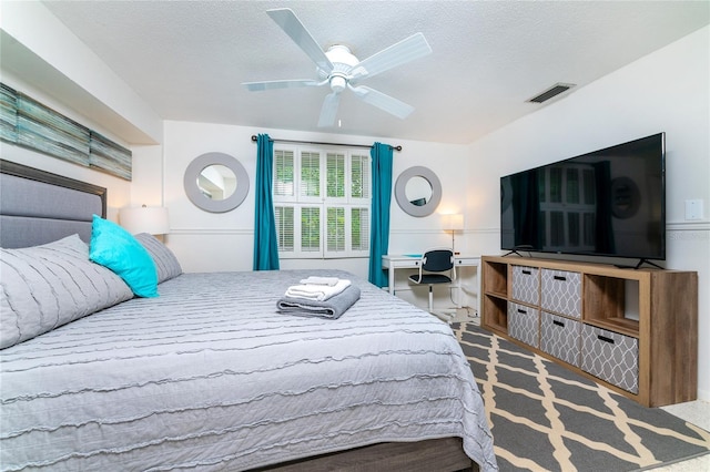 bedroom with a textured ceiling, a ceiling fan, and visible vents