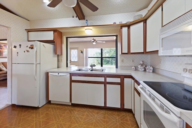 6305 Shalimar St, Port Charlotte, FL 33981 - kitchen with white appliances, a ceiling fan, wallpapered walls, light countertops, and white cabinets
