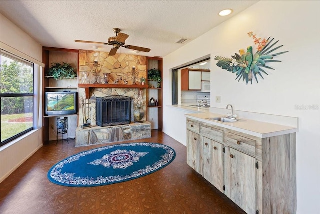 6305 Shalimar St, Port Charlotte, FL 33981 - living room with a textured ceiling, a ceiling fan, and a fireplace