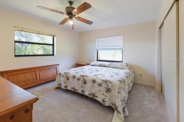 6305 Shalimar St, Port Charlotte, FL 33981 - bedroom featuring multiple windows, light carpet, a closet, a textured ceiling, and ceiling fan