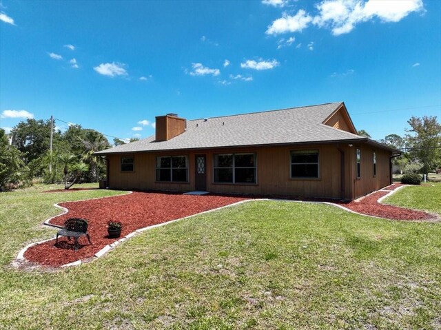 6305 Shalimar St, Port Charlotte, FL 33981 - back of property with a chimney and a lawn