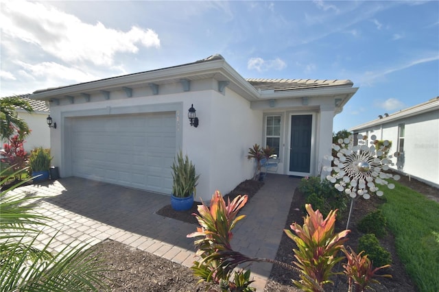 view of front of property featuring an attached garage, driveway, and stucco siding