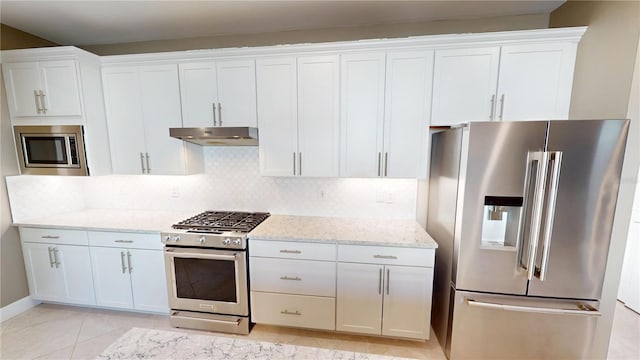 kitchen featuring stainless steel appliances, under cabinet range hood, and white cabinetry