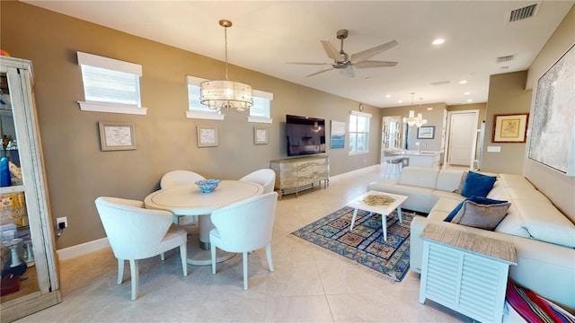 living area featuring visible vents, recessed lighting, light tile patterned floors, and ceiling fan with notable chandelier