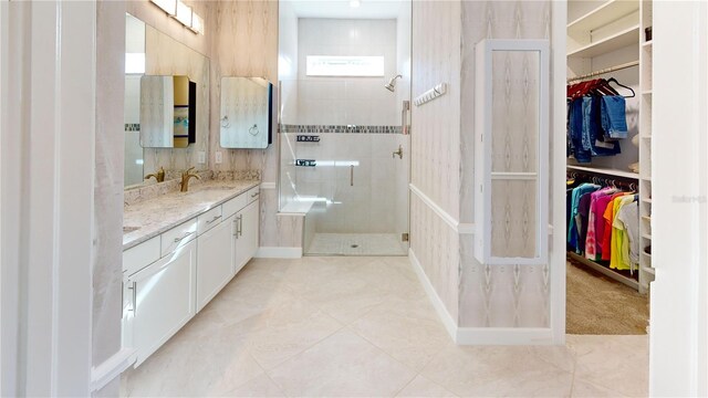 full bathroom with a walk in shower, a spacious closet, vanity, and tile patterned floors
