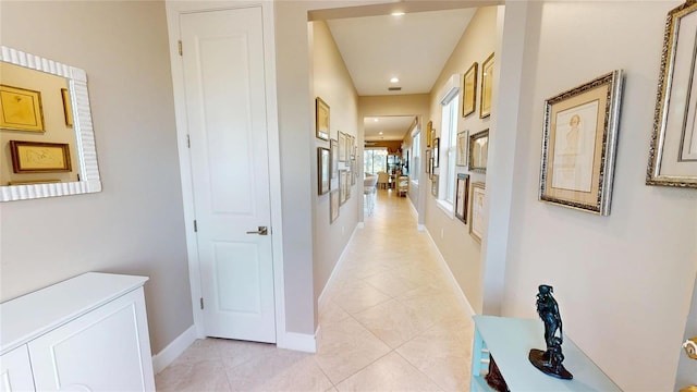 hallway with recessed lighting, light tile patterned floors, and baseboards
