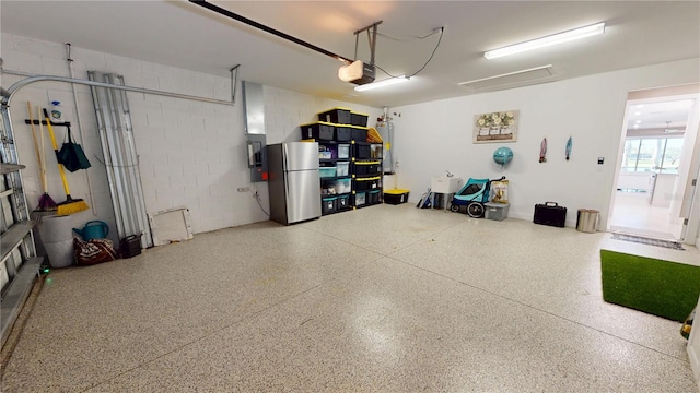 garage featuring a garage door opener, freestanding refrigerator, and concrete block wall