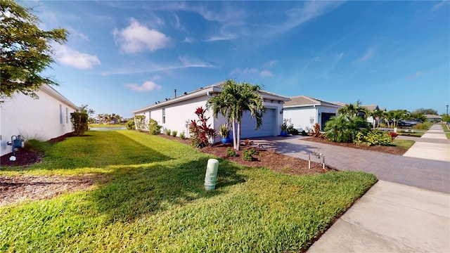 view of side of property with a garage, a yard, stucco siding, and decorative driveway
