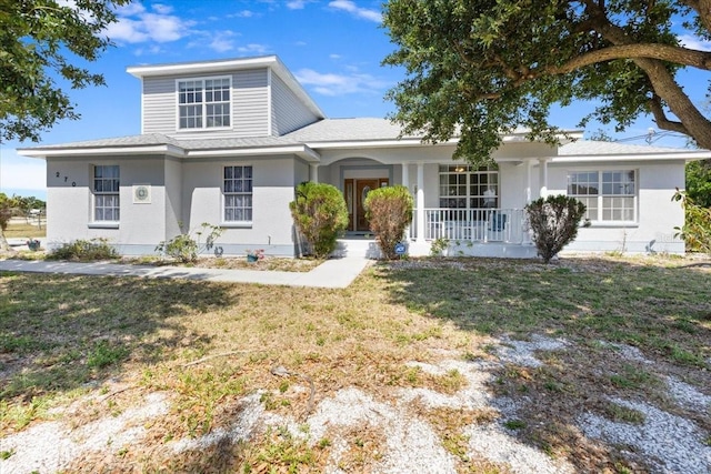 view of front of property featuring a porch, a front yard, and stucco siding