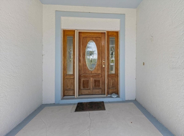 doorway to property featuring stucco siding