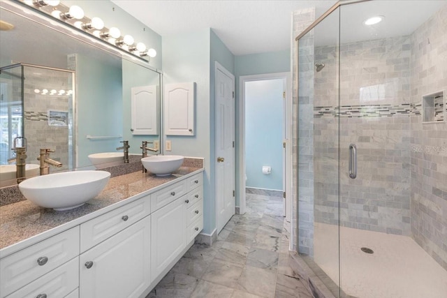 full bathroom featuring marble finish floor, a stall shower, and a sink