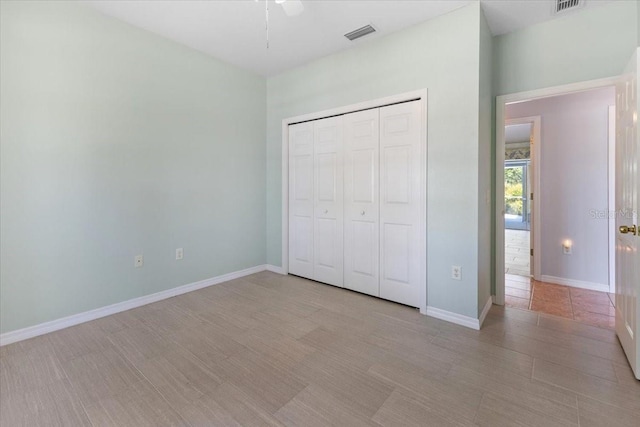 unfurnished bedroom with a closet, visible vents, a ceiling fan, and baseboards