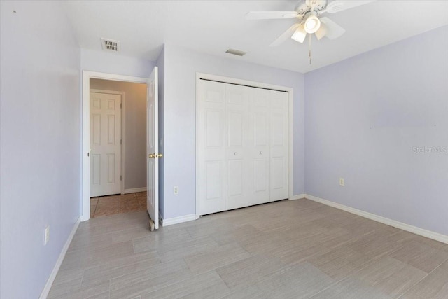 unfurnished bedroom featuring a closet, visible vents, baseboards, and ceiling fan