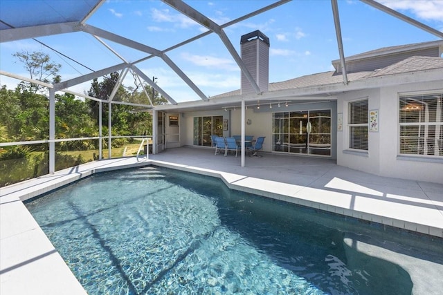 outdoor pool with glass enclosure and a patio
