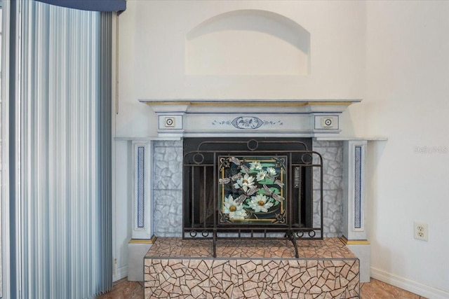 interior details with baseboards and a fireplace with raised hearth