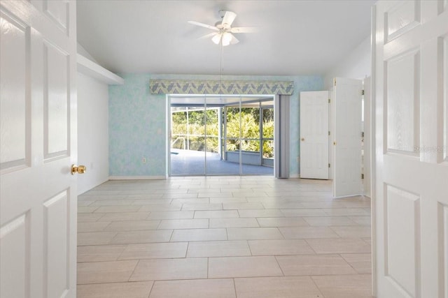 spare room with ceiling fan, lofted ceiling, and baseboards