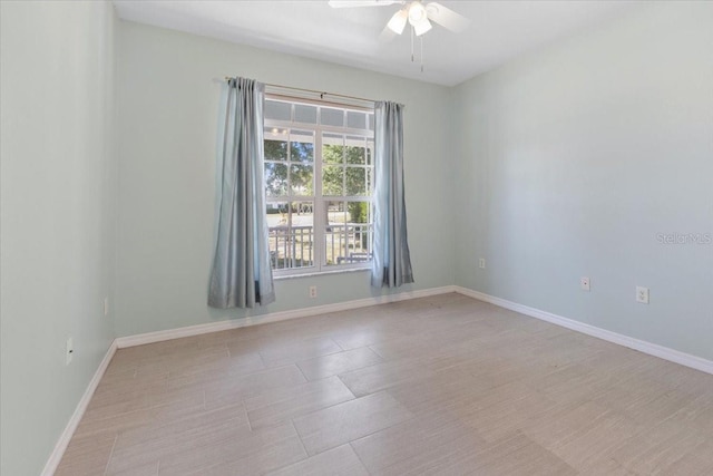 empty room with ceiling fan and baseboards