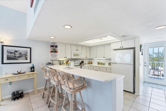 7554 Palm Island Dr S Unit 1822, Placida, FL 33946 - kitchen with a peninsula, white appliances, visible vents, light countertops, and light tile patterned floors