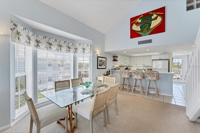 7554 Palm Island Dr S Unit 1822, Placida, FL 33946 - dining space featuring light colored carpet, light tile patterned flooring, high vaulted ceiling, and visible vents