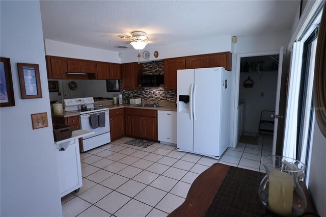 kitchen with white appliances, decorative backsplash, light tile patterned floors, light countertops, and ceiling fan
