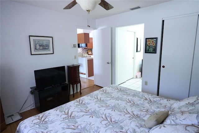 bedroom with a closet, visible vents, ceiling fan, and wood finished floors