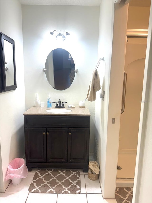 bathroom featuring tile patterned floors, a shower stall, and vanity