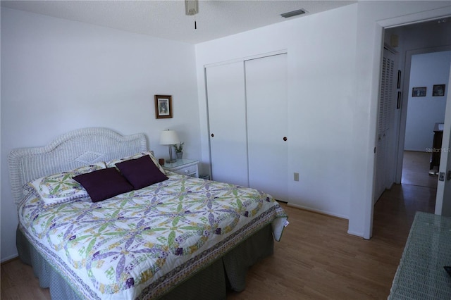 bedroom featuring a closet, visible vents, and wood finished floors
