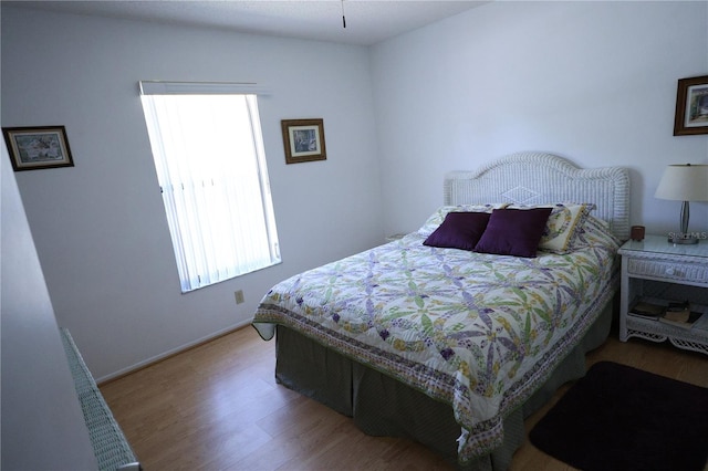 bedroom with baseboards and wood finished floors