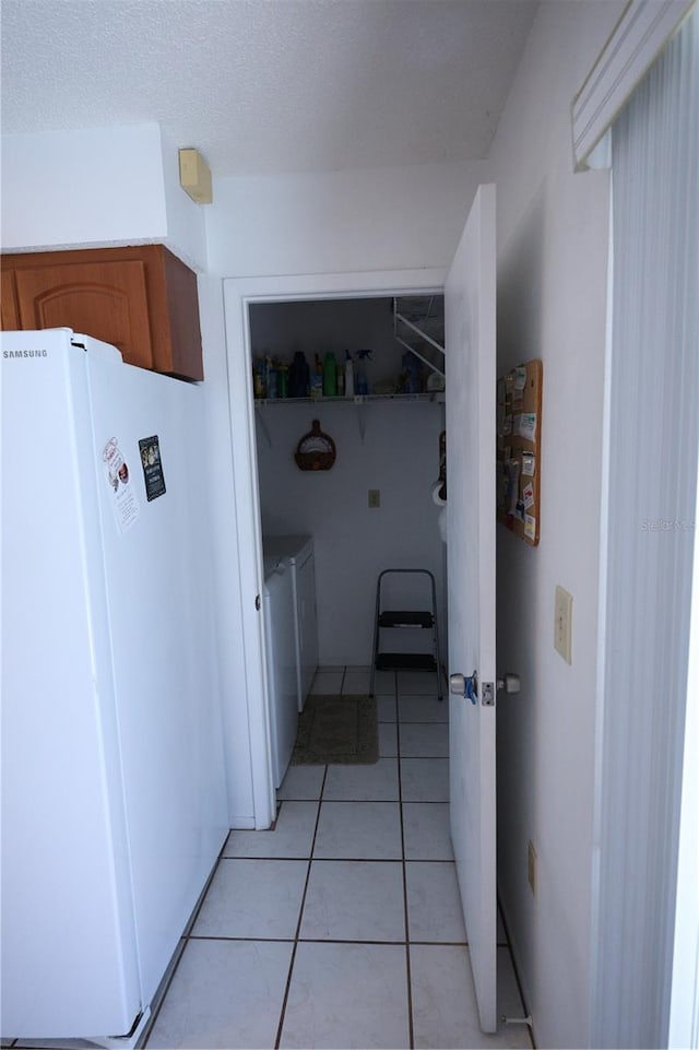 laundry room with light tile patterned flooring, washing machine and clothes dryer, and laundry area