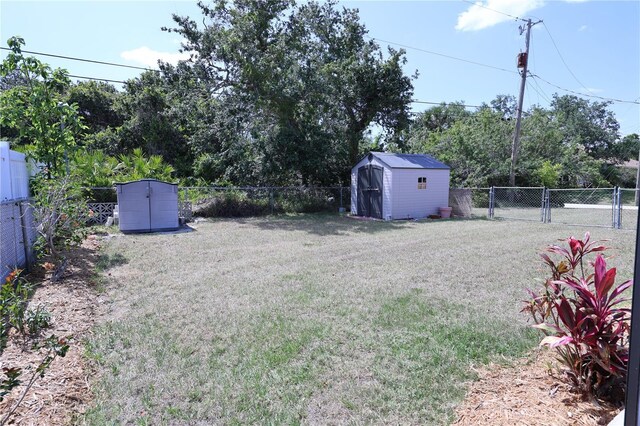 view of yard featuring an outdoor structure, a storage unit, and a fenced backyard