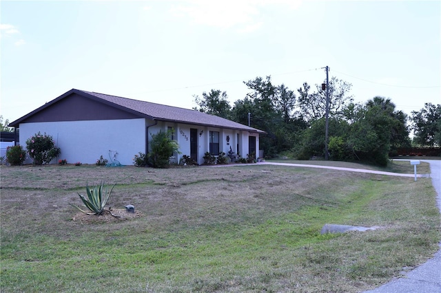 ranch-style house with a front yard and stucco siding