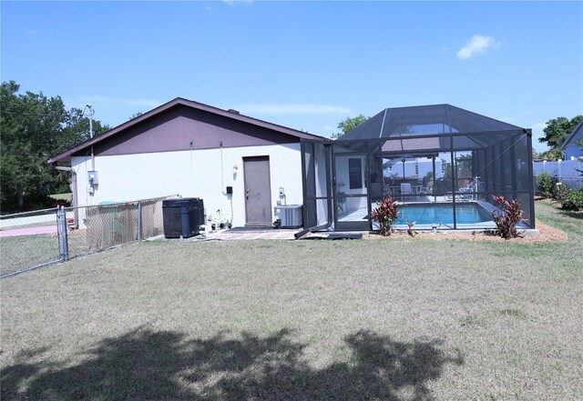 exterior space featuring a yard, fence, a fenced in pool, central AC, and a lanai