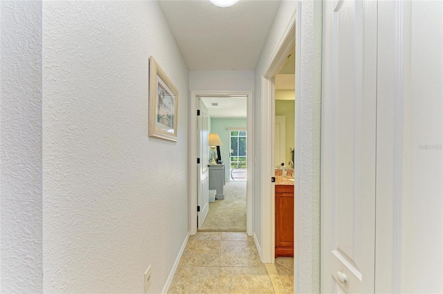 68 Long Meadow Ln, Rotonda West, FL 33947 - hallway featuring a textured wall and baseboards