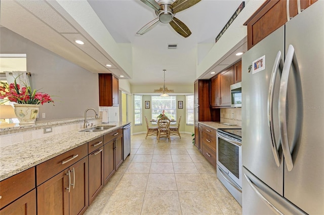 68 Long Meadow Ln, Rotonda West, FL 33947 - kitchen with light stone counters, a sink, light tile patterned floors, stainless steel appliances, and visible vents
