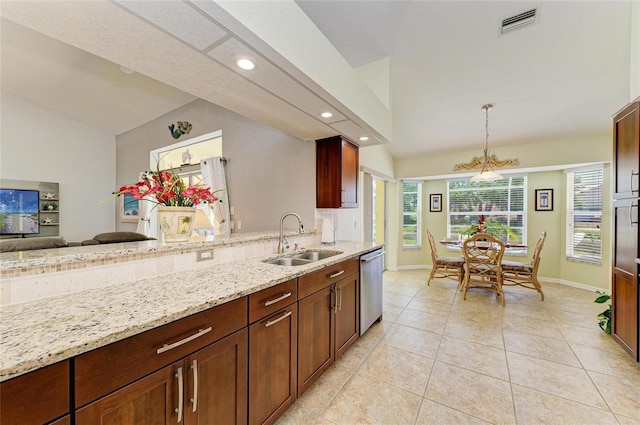 68 Long Meadow Ln, Rotonda West, FL 33947 - kitchen featuring stainless steel dishwasher, a sink, lofted ceiling, pendant lighting, and light stone countertops