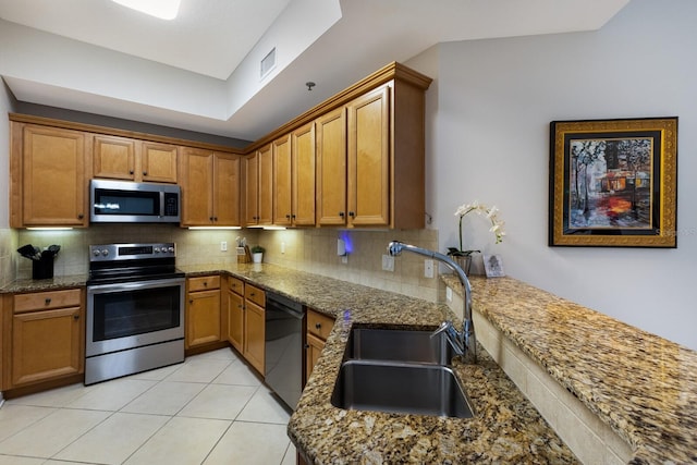 8500 Amberjack Cir Unit 102, Englewood, FL 34224 - kitchen with stainless steel appliances, a sink, brown cabinetry, and tasteful backsplash