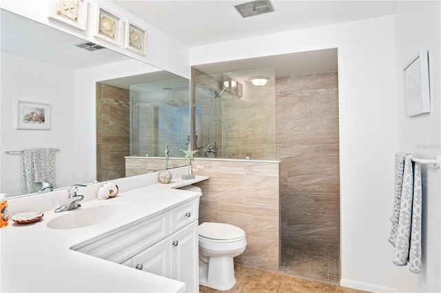 bathroom featuring a walk in shower, tile patterned flooring, vanity, toilet, and visible vents