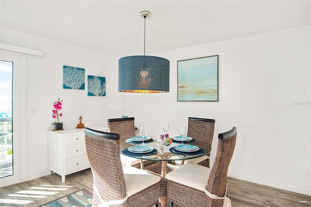 dining space with baseboards, plenty of natural light, and light wood-type flooring