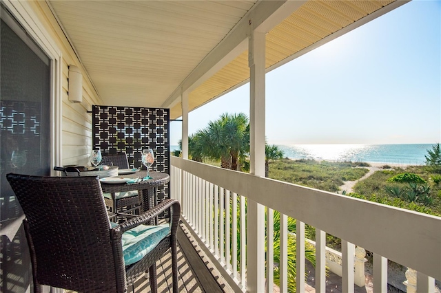 balcony featuring a beach view and a water view