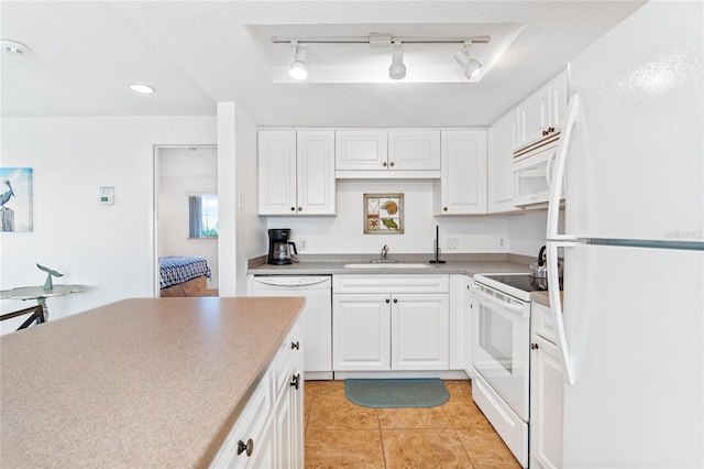 kitchen with a sink, light tile patterned flooring, white appliances, and white cabinetry