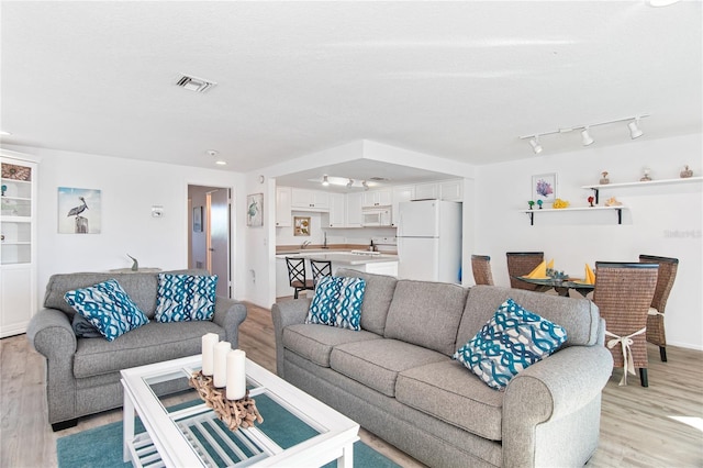 living room with visible vents and light wood-type flooring