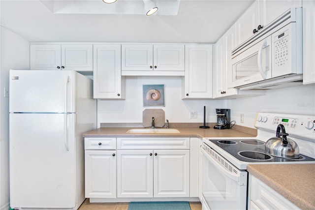 kitchen featuring a sink, white cabinets, white appliances, and light countertops