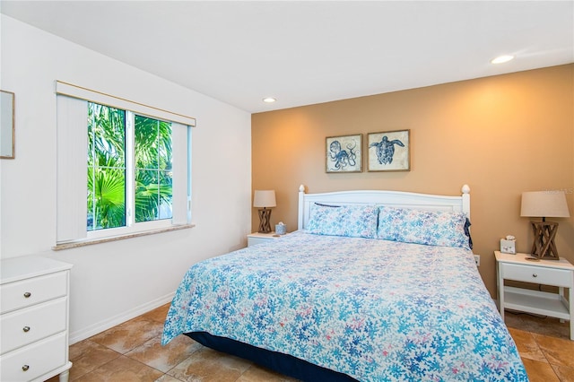 bedroom with light tile patterned floors, baseboards, and recessed lighting