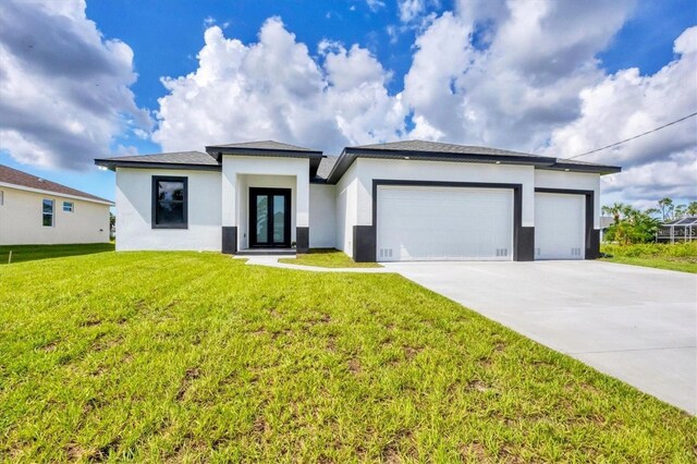 17456 Belie Way, Punta Gorda, FL 33955 - prairie-style house with a front yard, an attached garage, stucco siding, and driveway