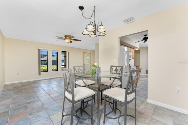 39 Bunker Pl, Rotonda West, FL 33947 - dining area with stone finish flooring, baseboards, visible vents, and ceiling fan with notable chandelier